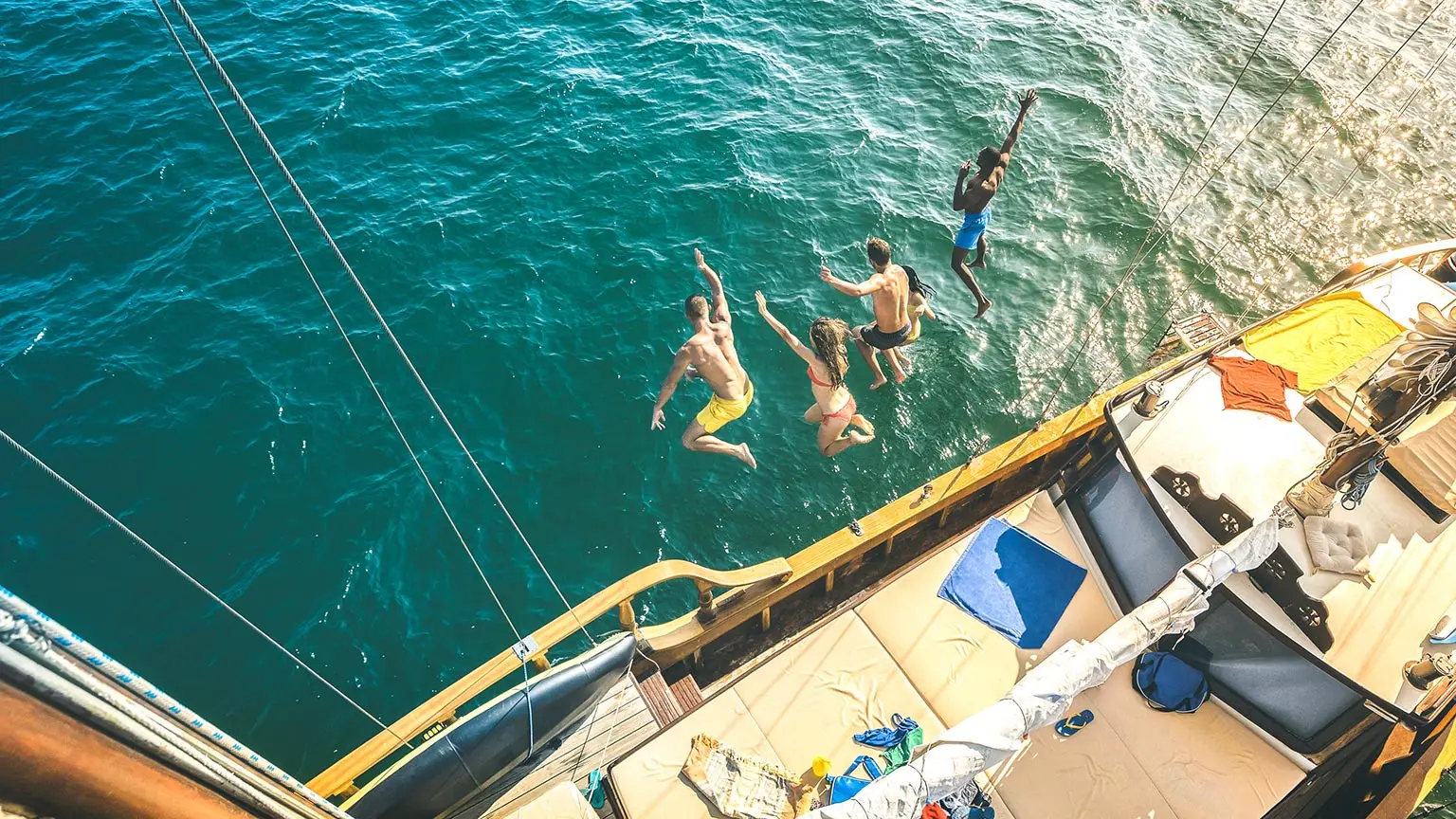 People jumping off a boat in Italy into the Mediterranean