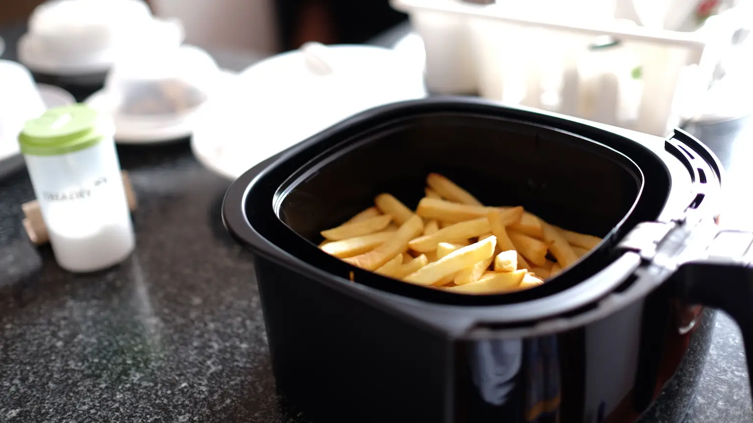 Close up of an air fryer filled with chips.