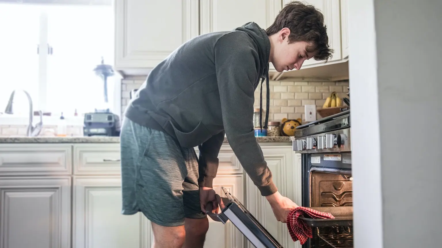 Teenage boy cooking in kitchen