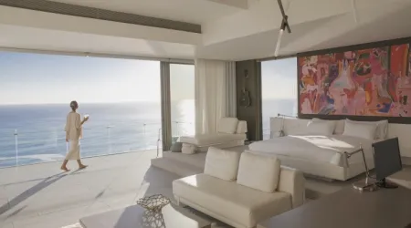 Woman walking on sunny modern, luxury home showcase bedroom balcony with ocean view