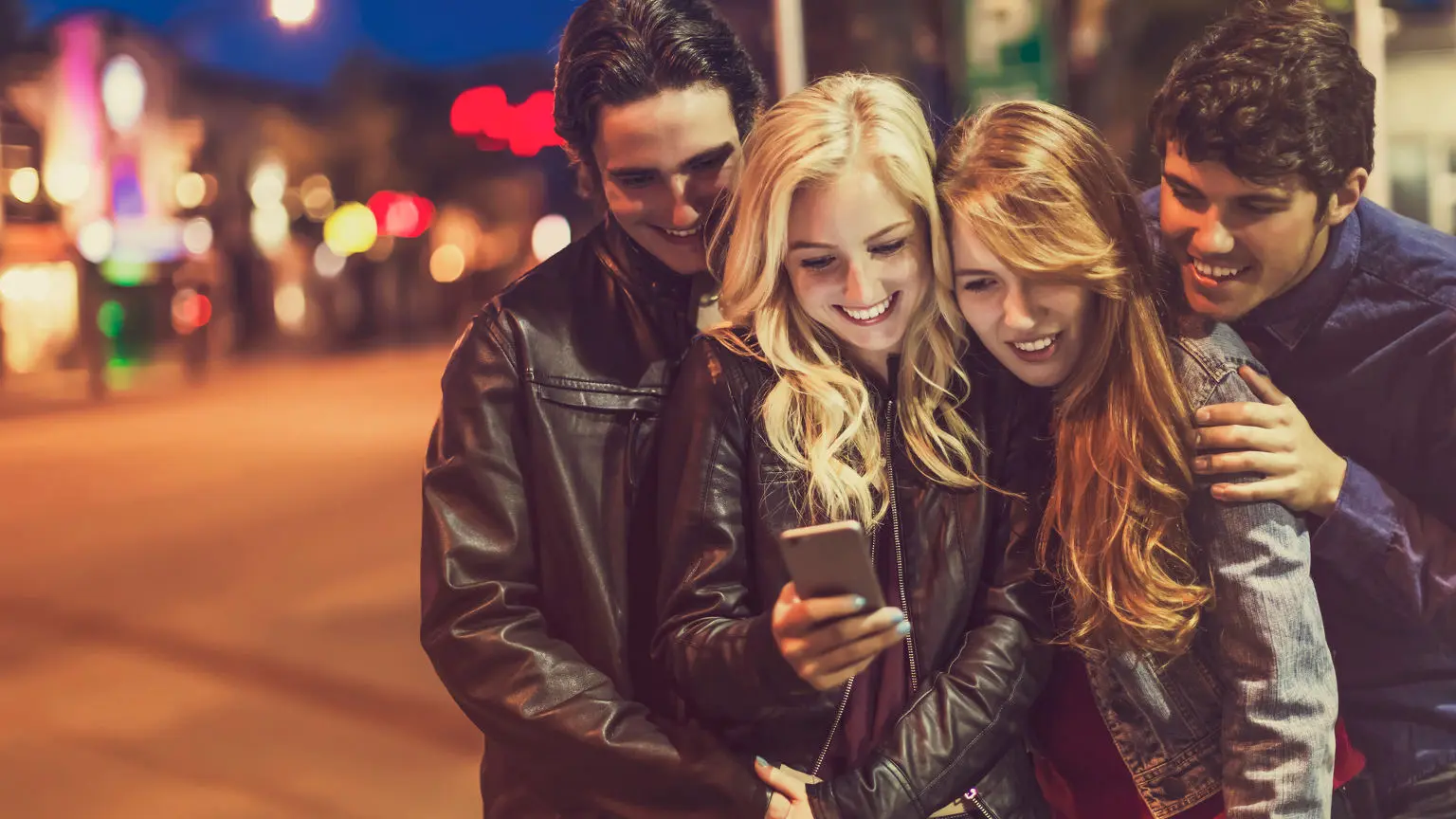 Group smiling and looking at phone