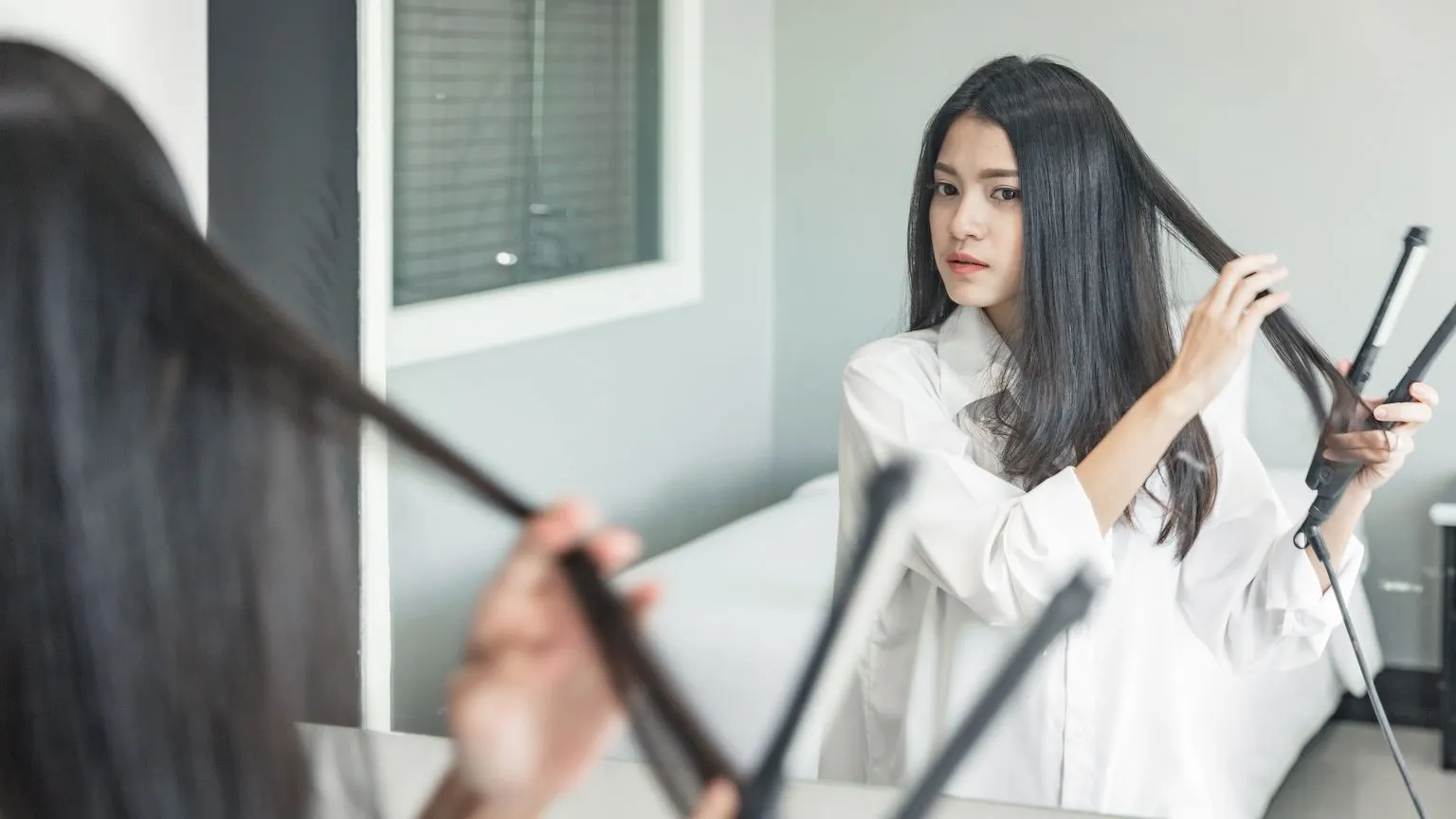 Woman using a hair straightener