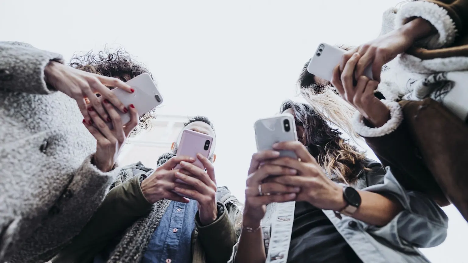 A group of young people holding up their smartphones