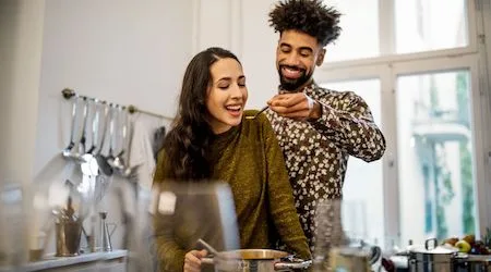 Man cooking and feeding his girlfriend soup