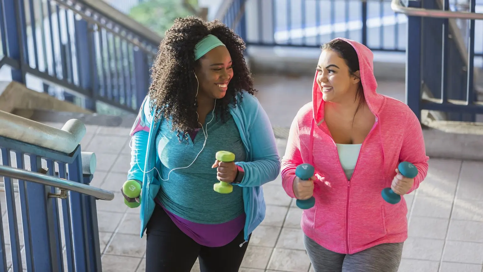 Two women exercising together in bright clothing