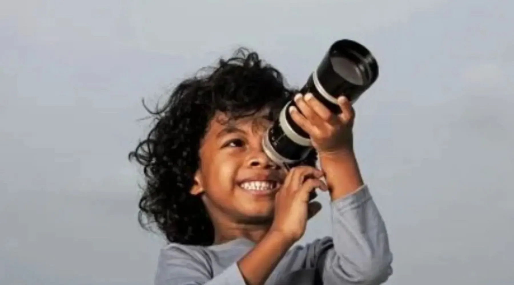 A kid using a telescope