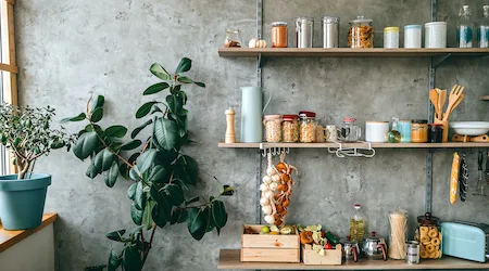 Uncooked groceries in glass jars arranged on wooden shelves of kitchen