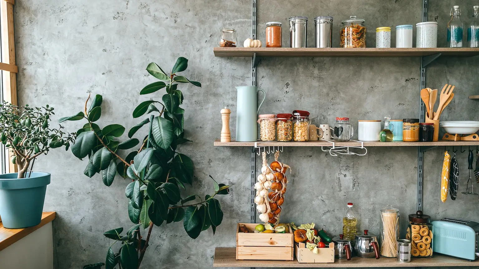 Uncooked groceries in glass jars arranged on wooden shelves of kitchen