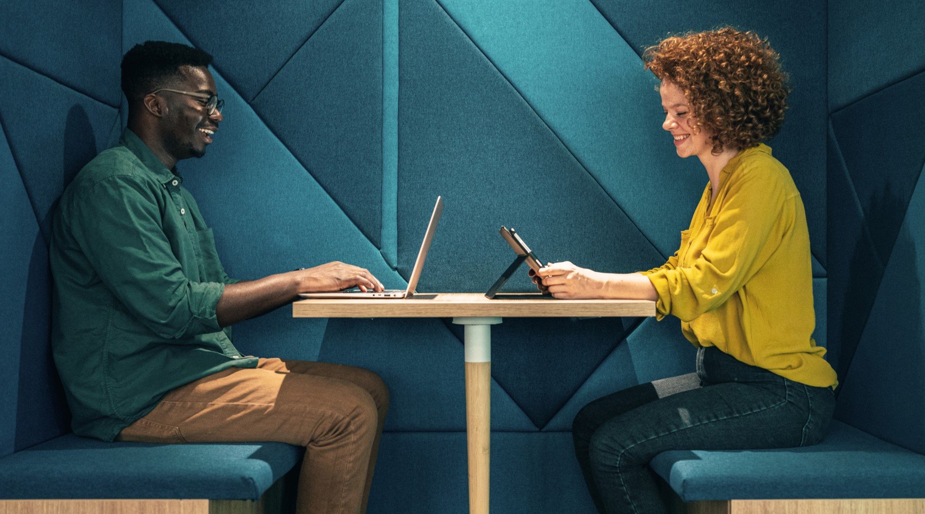 Two team members with their own devices in the office 
