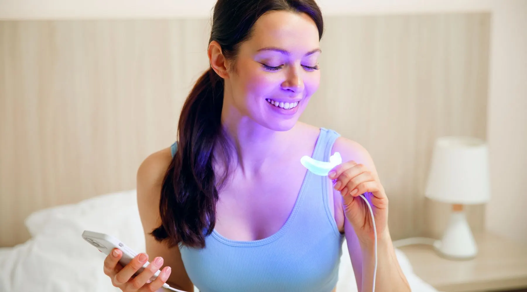 Woman holding a teeth whitening device