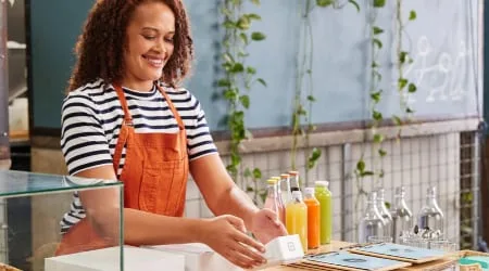 A woman in a cafe holding a square reader